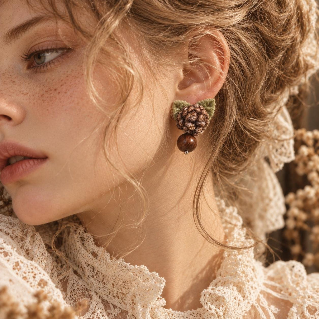 Hazelwood crochet-flower earring with a brown bead drop worn beside blonde hair.